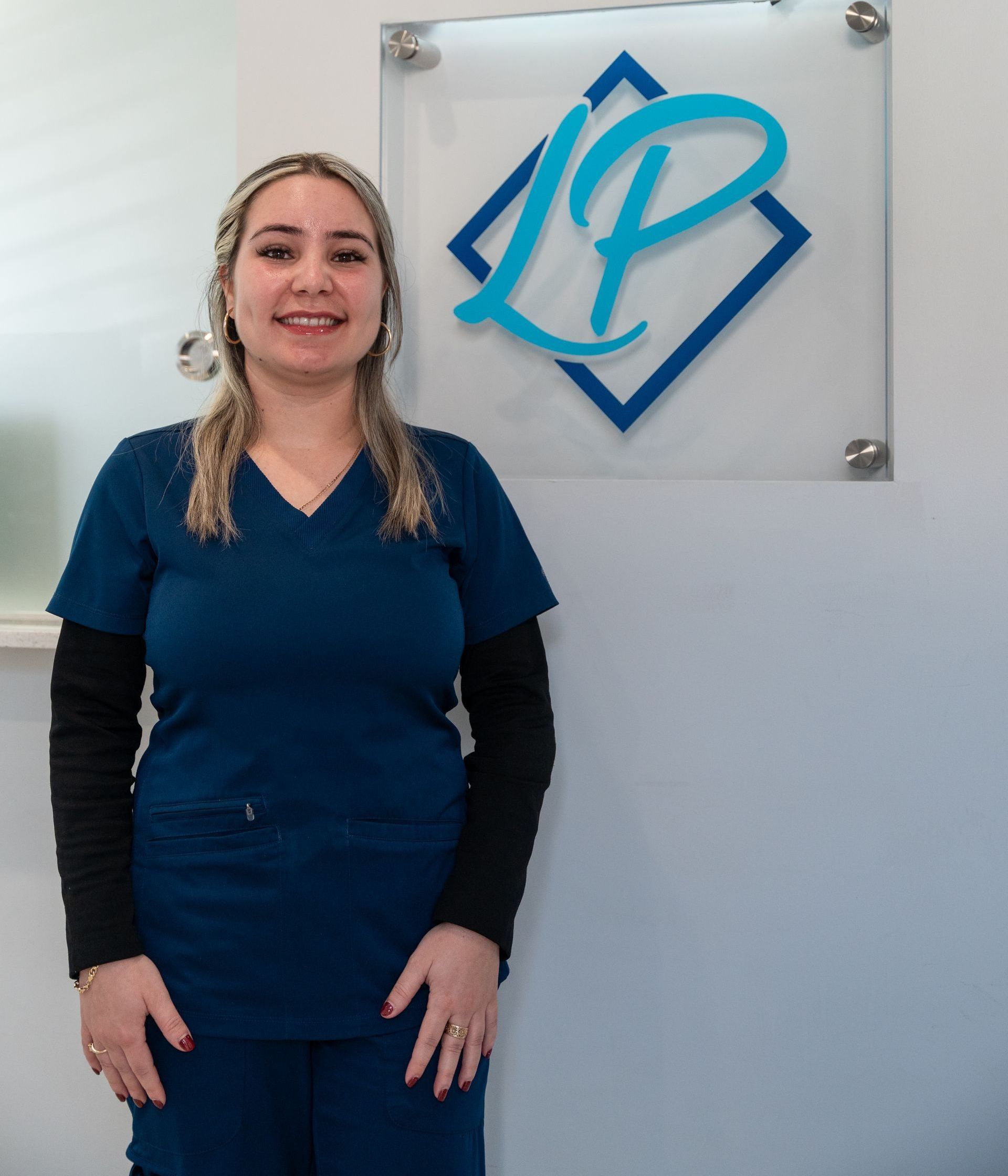 A woman stands in front of a sign that has the letter p on it
