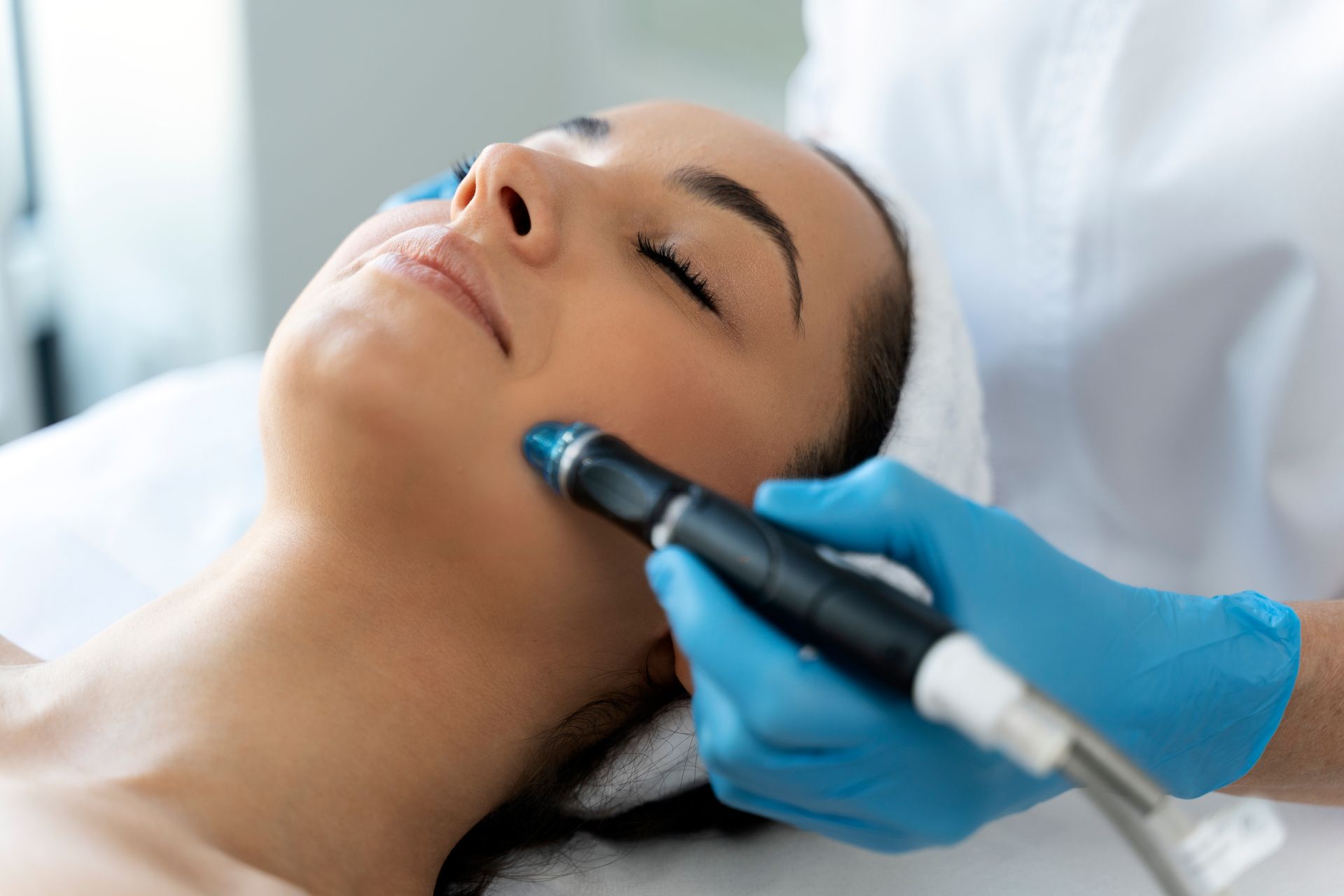 A woman is getting a facial treatment at a beauty salon.