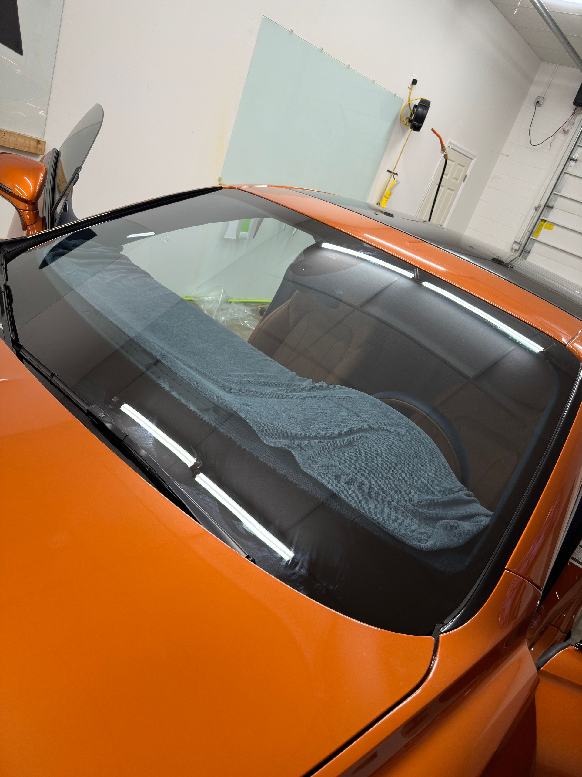 Orange sports car with tinted rear window, cloth inside.