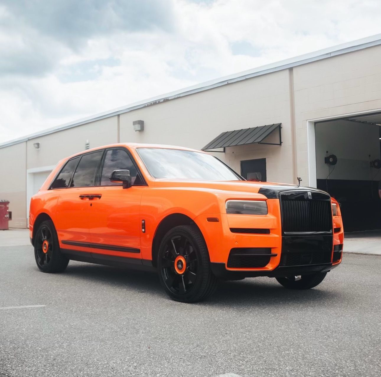Yellow and white VW ID. Buzz van with daisy decals, in a tinting shop.