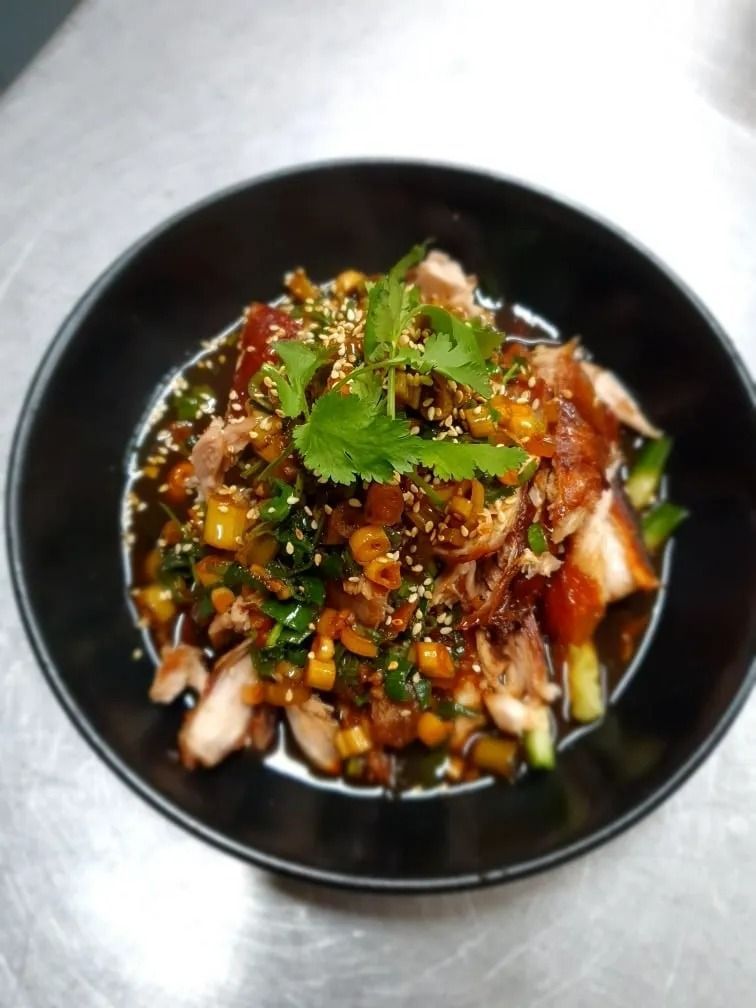 Chicken and Vegetable Salad in a Black Bowl and Garnished With Cilantro — L'il Buddha Asian Cuisine in Salamander Bay, NSW