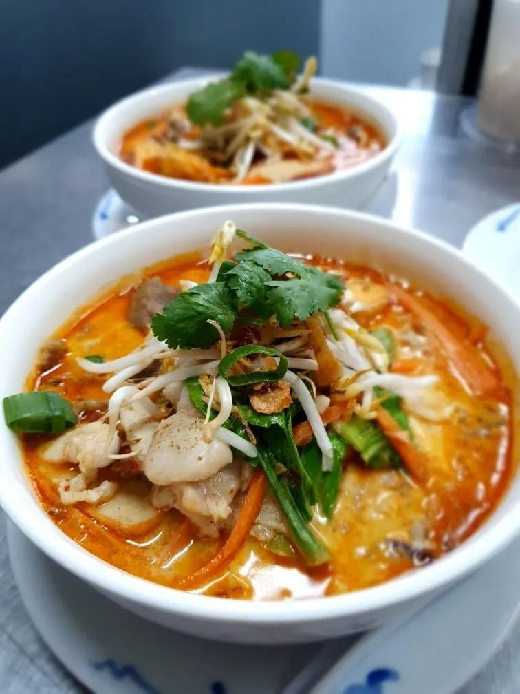 Two Bowls of Laksa Soup, Garnished With Sprouts and Cilantro, on a Counter — L'il Buddha Asian Cuisine in Salamander Bay, NSW