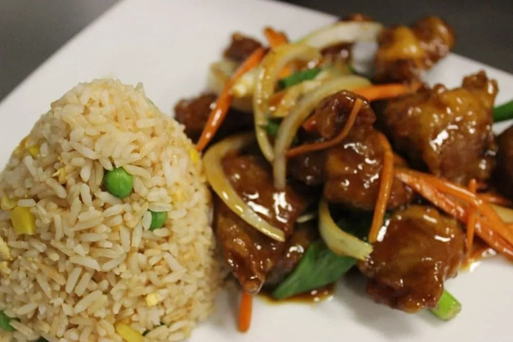 Fried Rice and a Dish of Glazed Meat With Vegetables on a White Plate — L'il Buddha Asian Cuisine in Salamander Bay, NSW