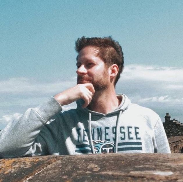 A man wearing a tennessee sweatshirt looks to the side