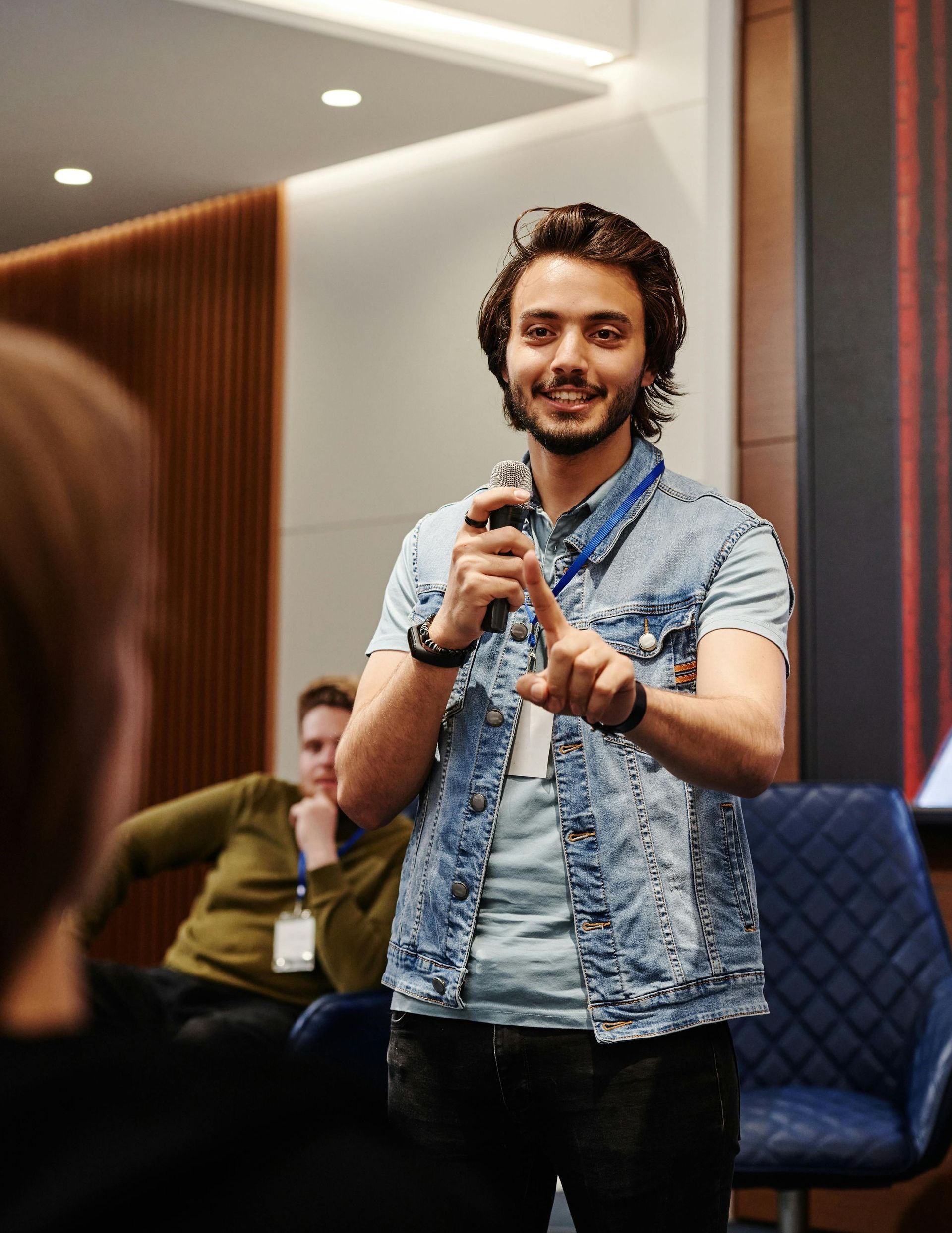 A man is holding a microphone in front of a group of people.