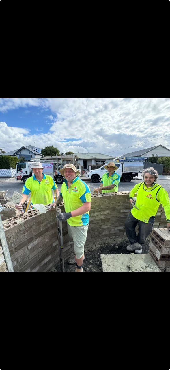 A group of construction workers are standing next to each other on a construction site.