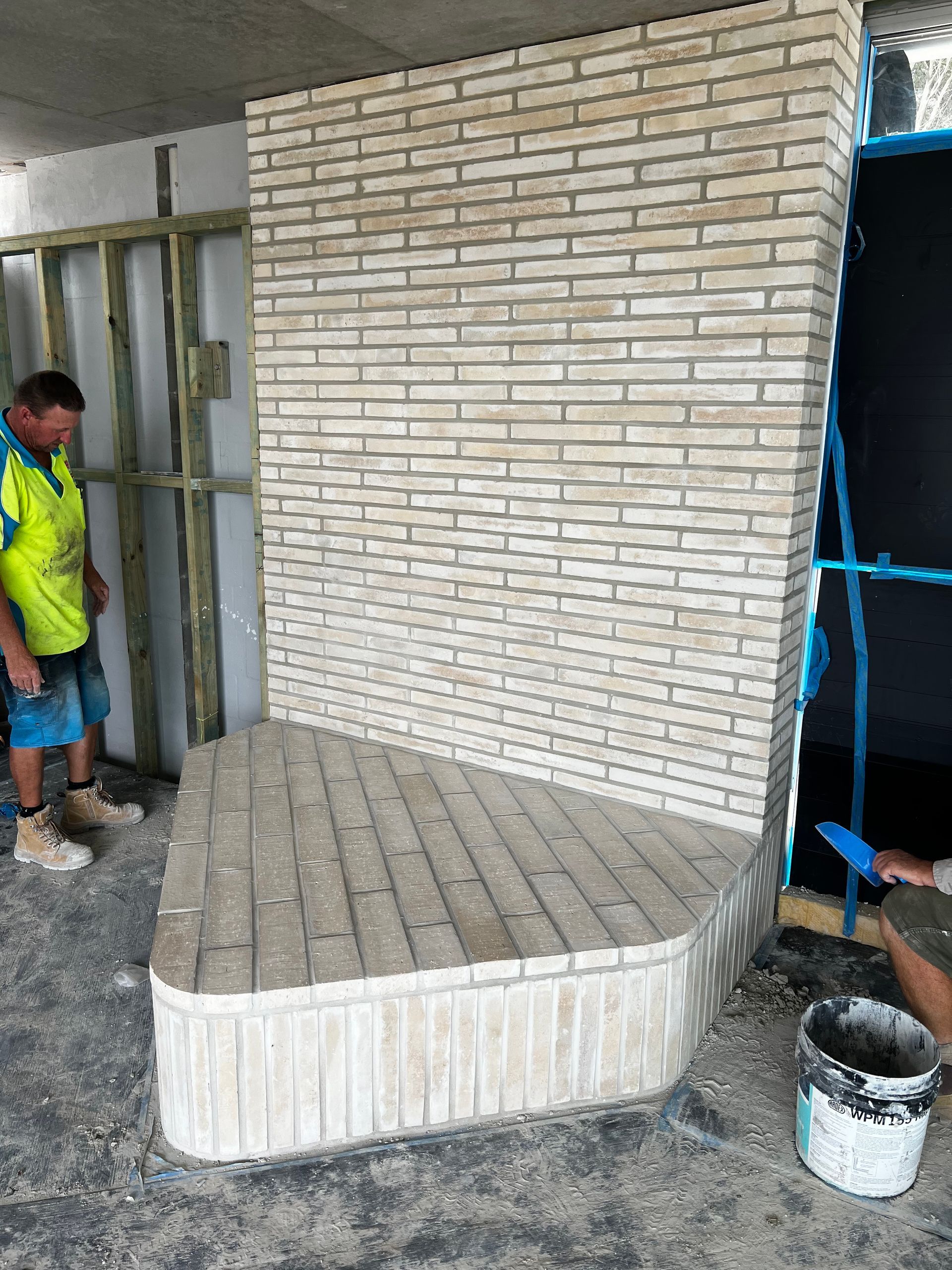 A room with a brick wall and a fireplace.