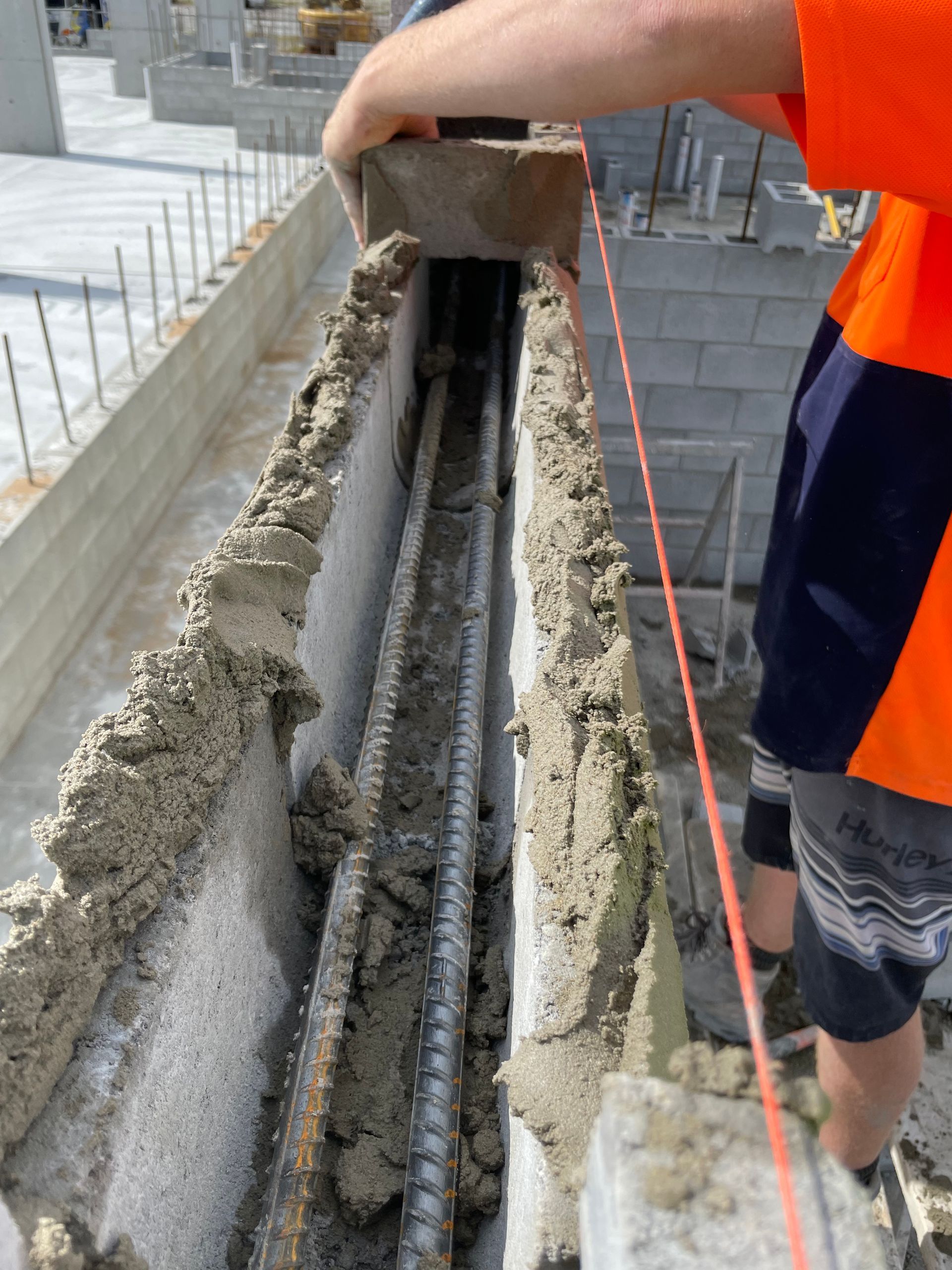 A construction worker is measuring a wall with a tape measure