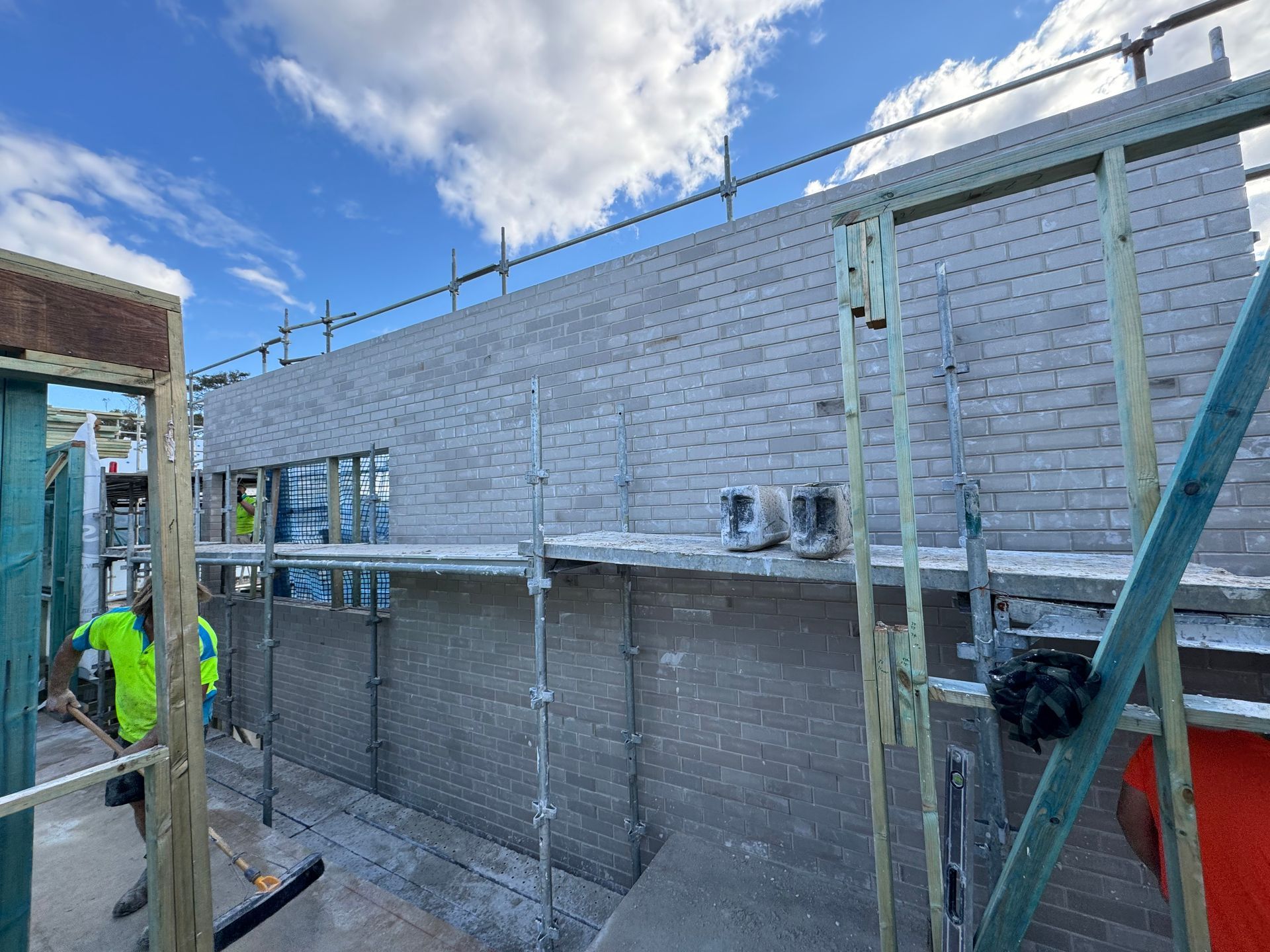 A large concrete wall is surrounded by dirt and trees.