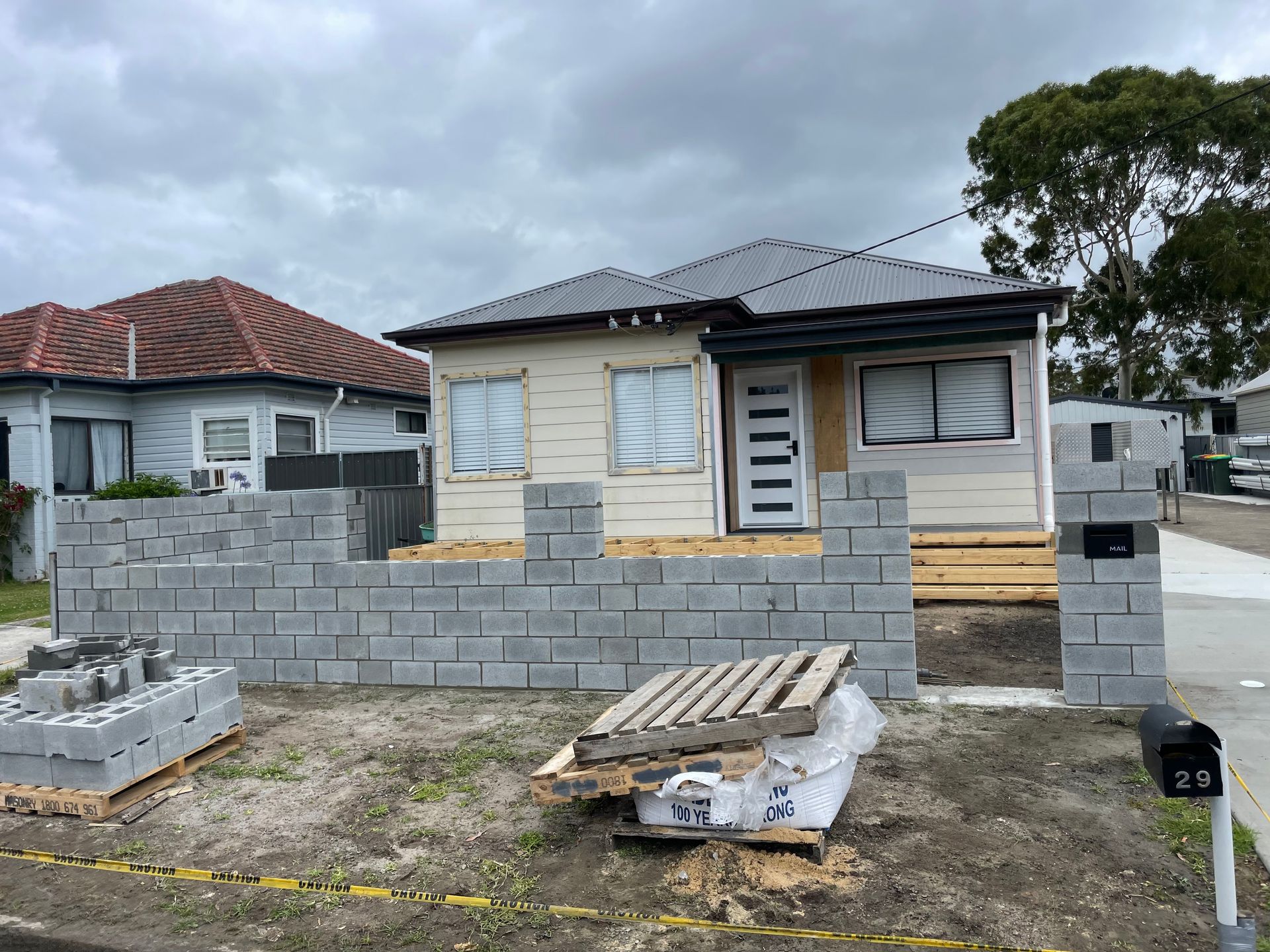 A house is being built with bricks in front of it.