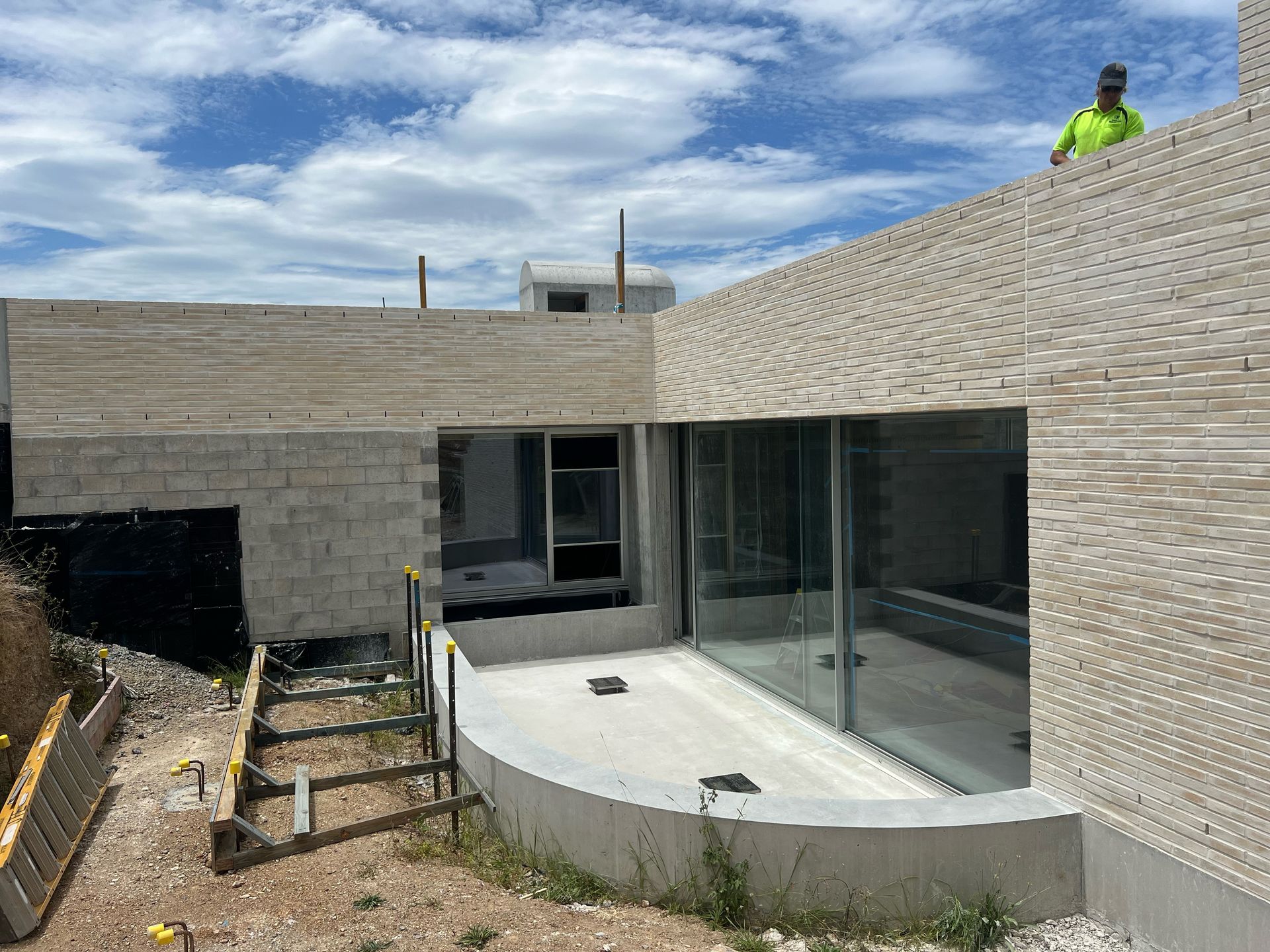 A man is standing on top of a building under construction.