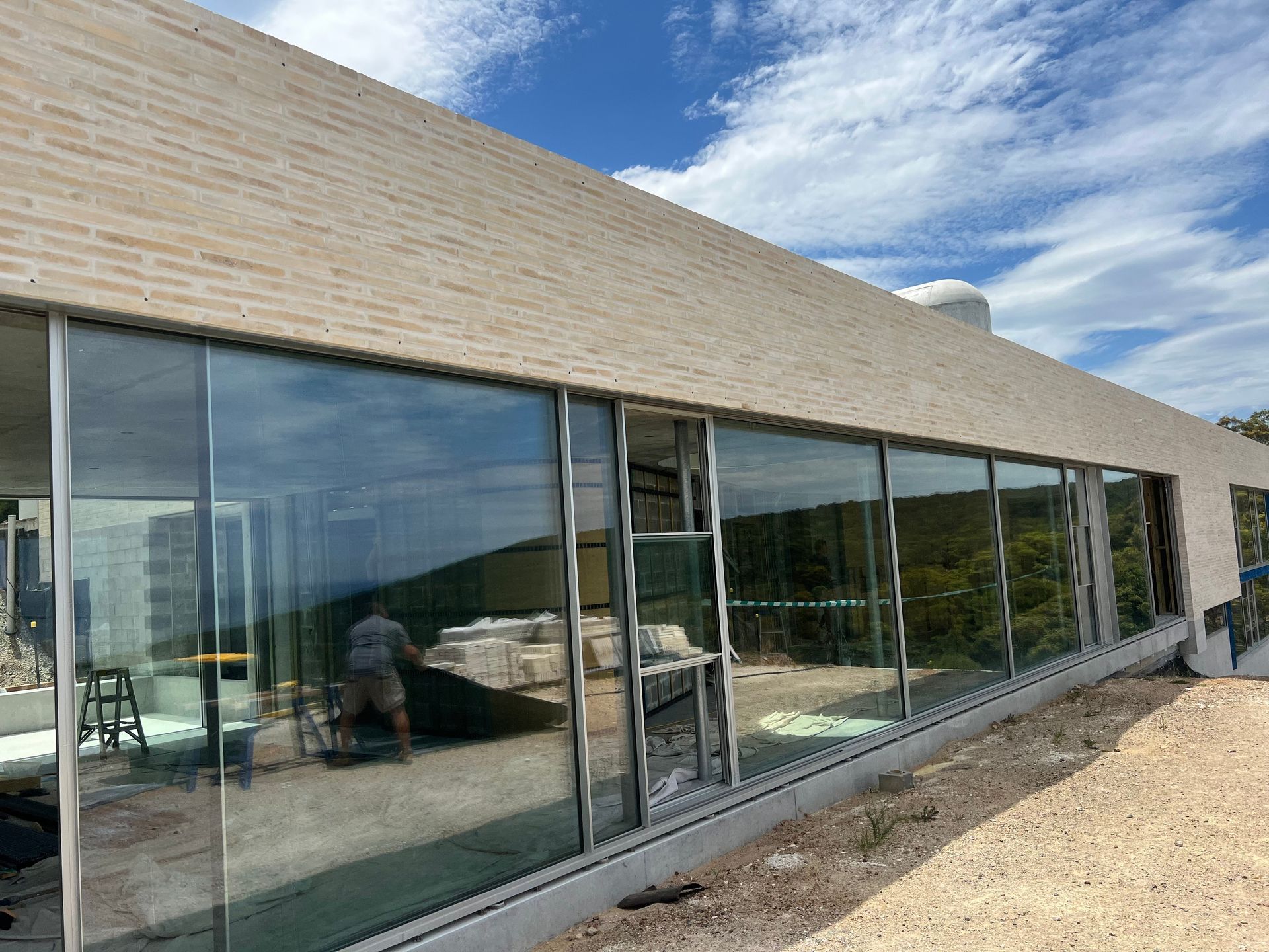 A building under construction with stairs and a pool in front of it.