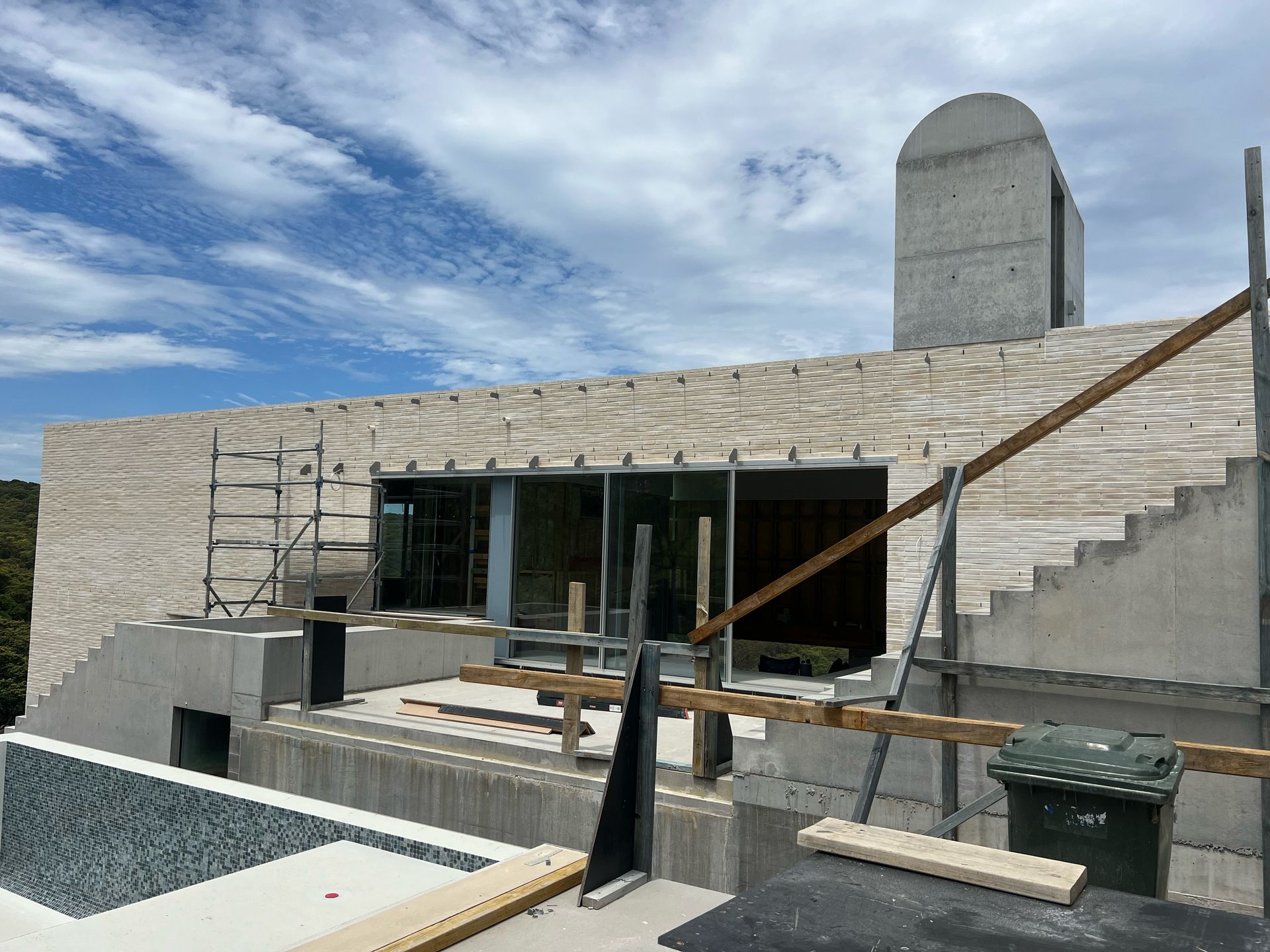 A large concrete structure is being built on top of a dirt hill.