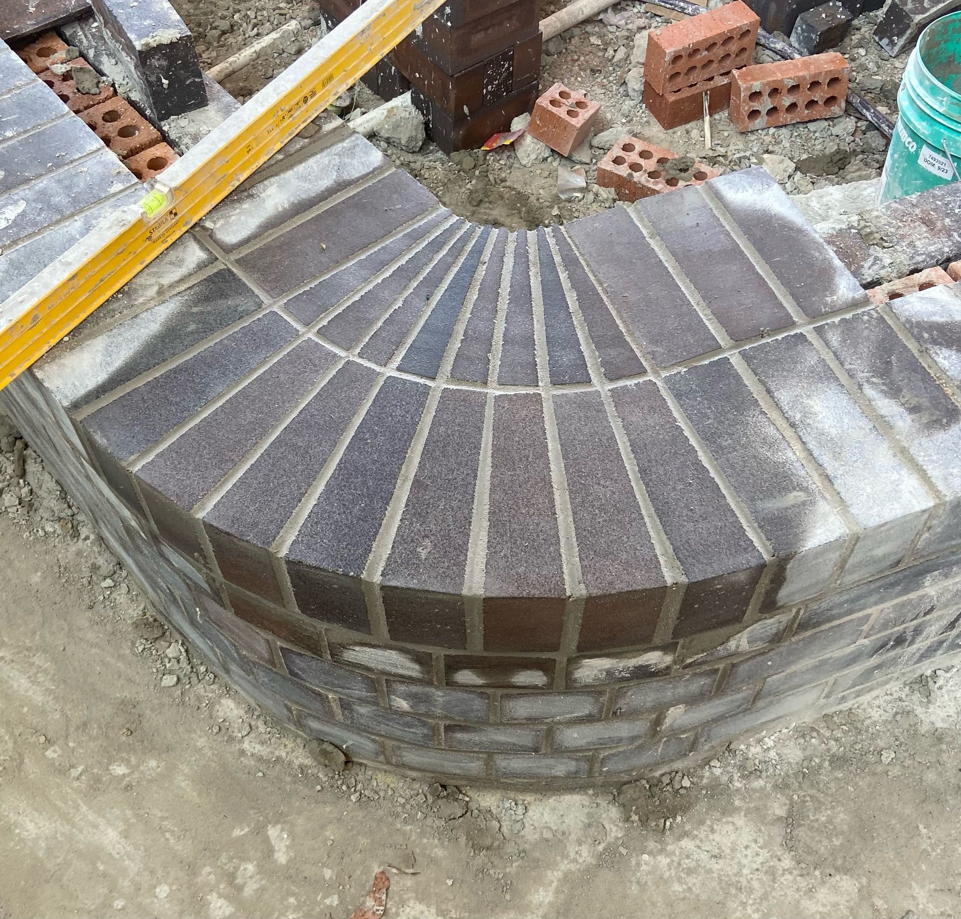 A yellow level is sitting on top of a brick wall