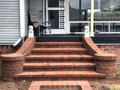 A Pile Of Bricks Is Sitting On The Ground In Front Of A Building – Newcastle, NSW - Newcastle Bricklaying Pty Ltd