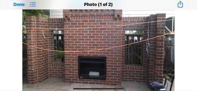 A brick walkway in a garden with a statue in the background.