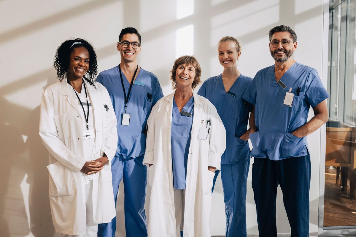 A group of doctors and nurses are posing for a picture in a hospital.