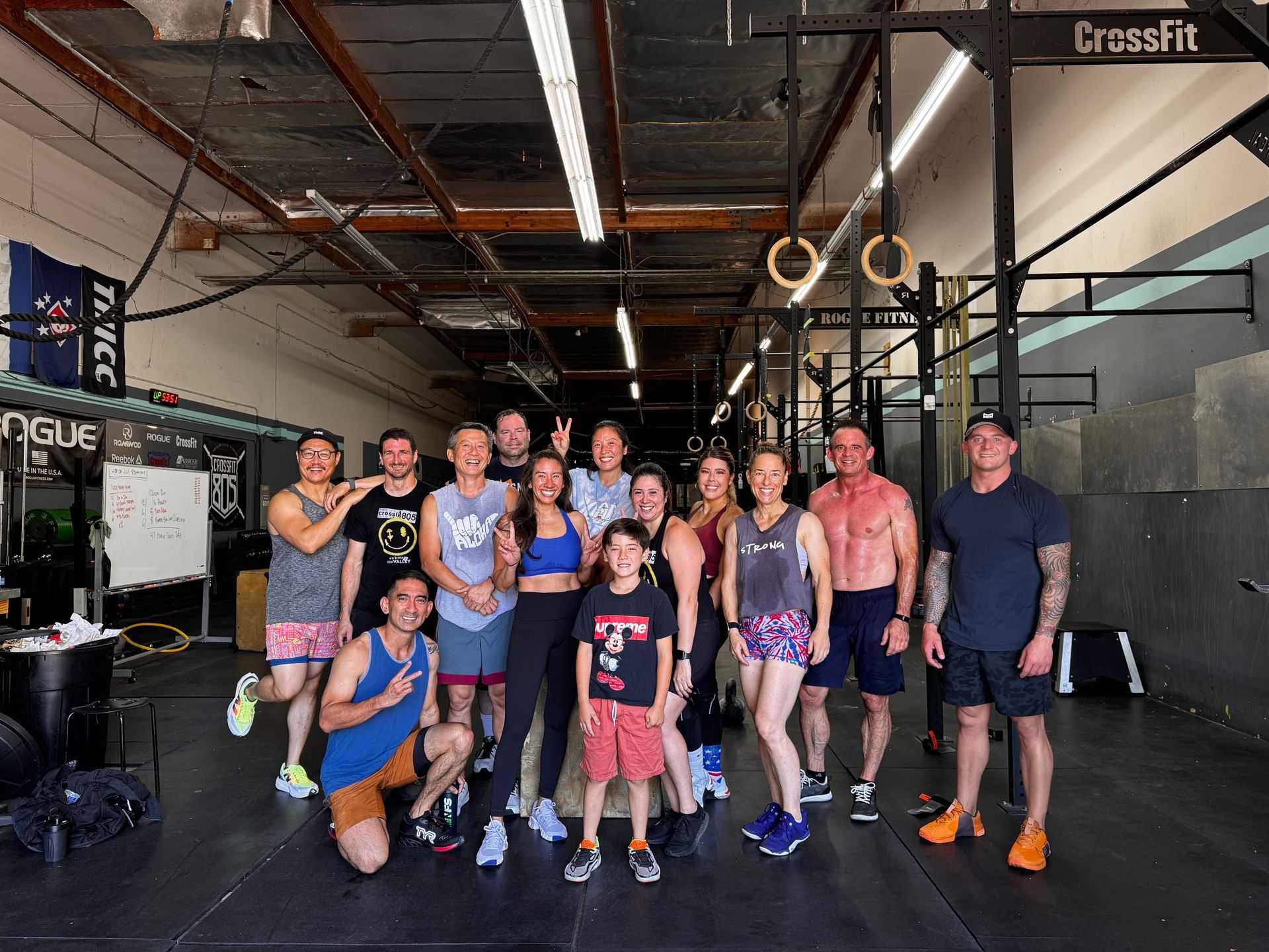 Group of people smiling in a CrossFit gym. 