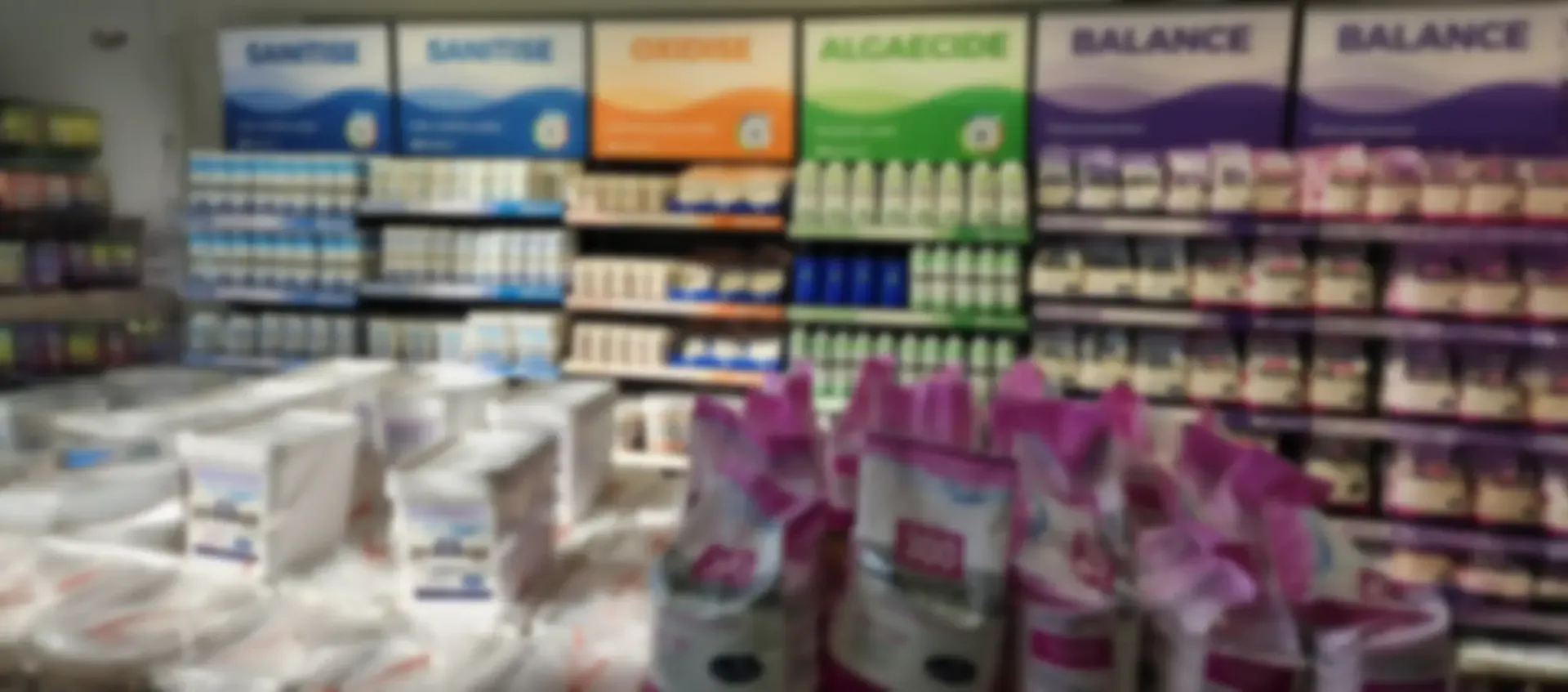Shelves of pool chemicals n a store, with colourful product signage above.