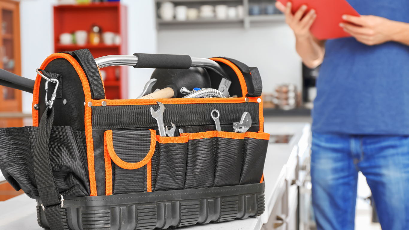 A man is standing next to a tool bag filled with tools.