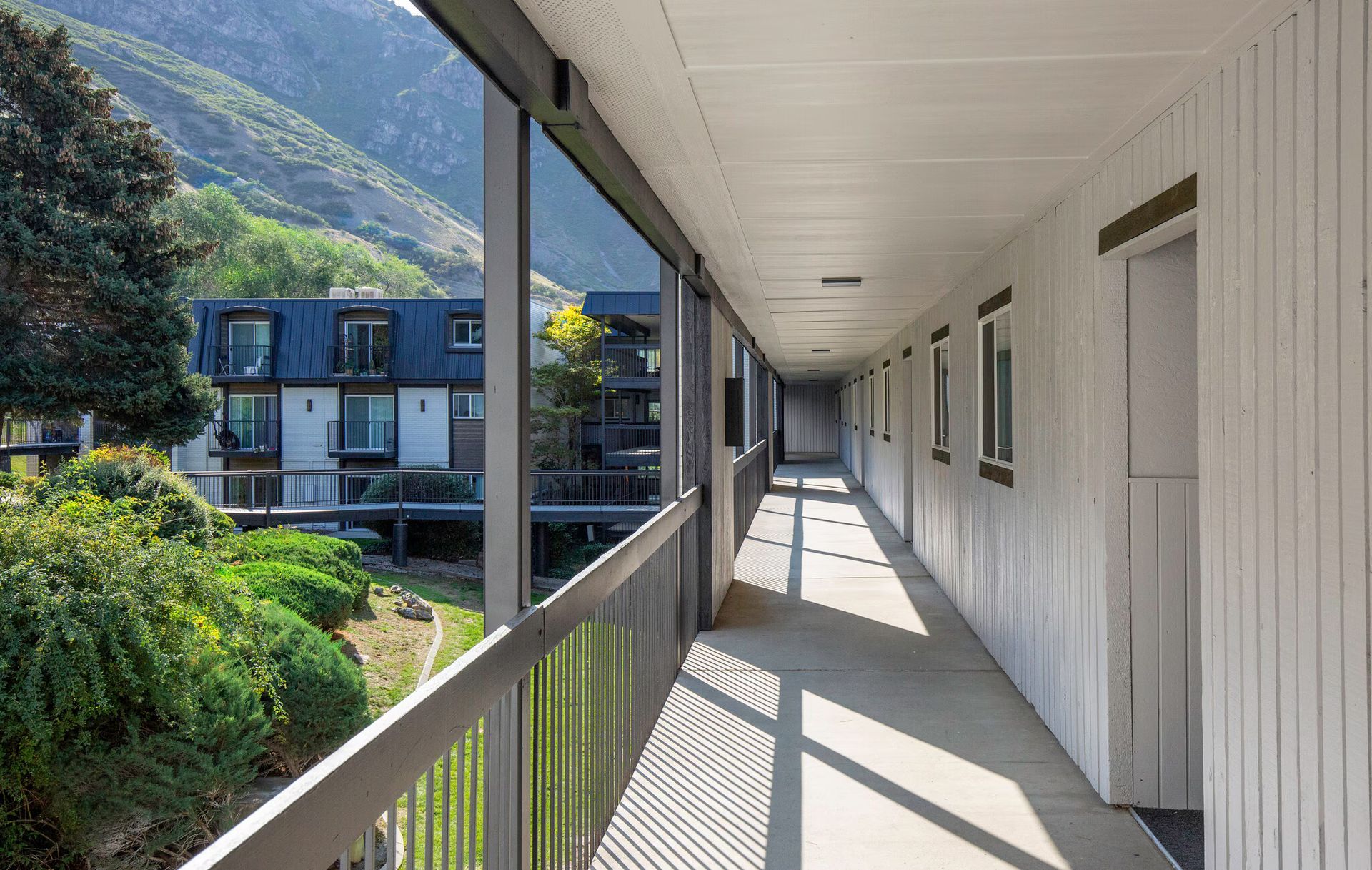 Exterior apartment corridor with a mountain view.
