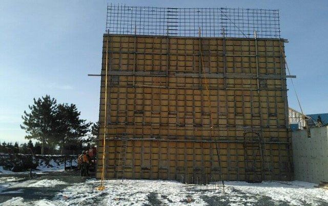 Un grand bâtiment est en construction dans la neige