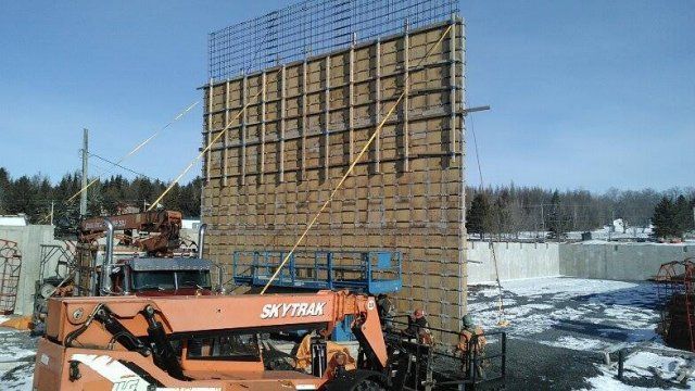 Une grue skytrax est utilisée pour construire un mur.
