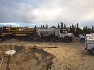 Un gros camion blanc est garé dans un champ de terre.