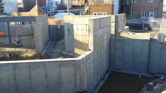 Un mur de béton est en cours de construction dans un sous-sol.