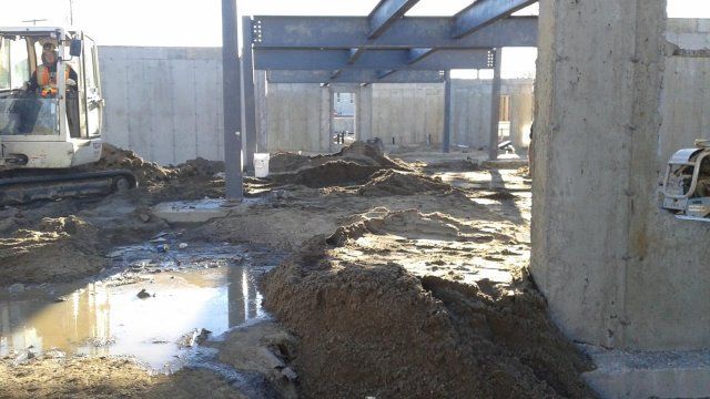 Un chantier de construction avec un gros tas de terre au milieu