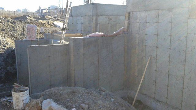 Un tas de terre se trouve devant un mur de béton.