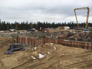 Un chantier de construction avec beaucoup de terre et d'arbres en arrière-plan