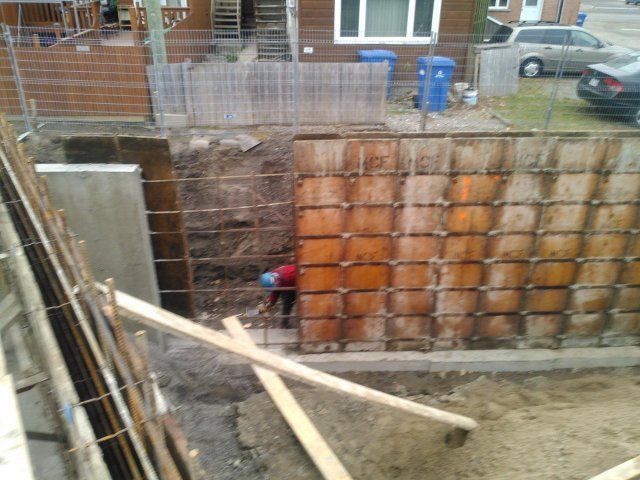 Un mur de béton est en cours de construction devant une maison
