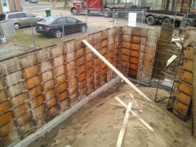 Une voiture est garée devant un mur en construction.