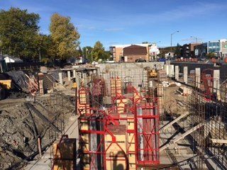 Un chantier de construction avec beaucoup de béton et quelques bâtiments en arrière-plan