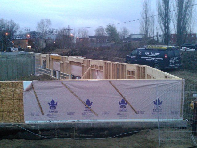 Un bâtiment en construction avec une camionnette garée en arrière-plan