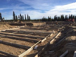 Un chantier de construction avec un ciel bleu et des arbres en arrière-plan