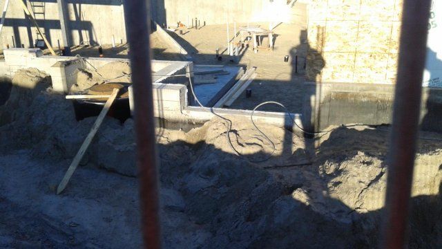 Un chantier de construction avec un tas de terre au premier plan