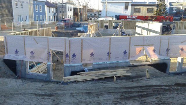 Une maison est en construction au milieu d'un champ de terre.