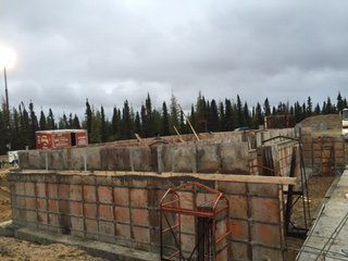 Un bâtiment en construction avec un ciel nuageux en arrière-plan.