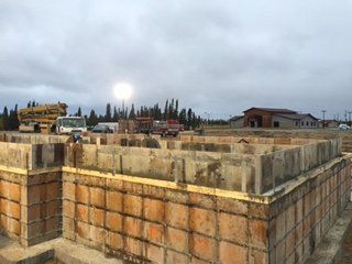Un grand mur de briques est en cours de construction sur un chantier de construction.