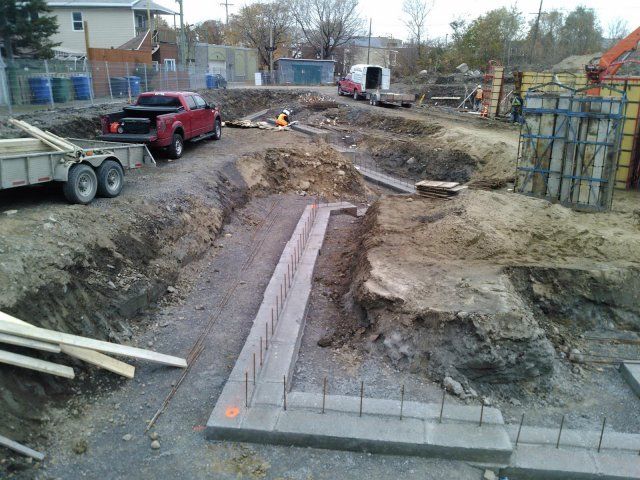 Un camion rouge est garé au milieu d'un chantier de construction