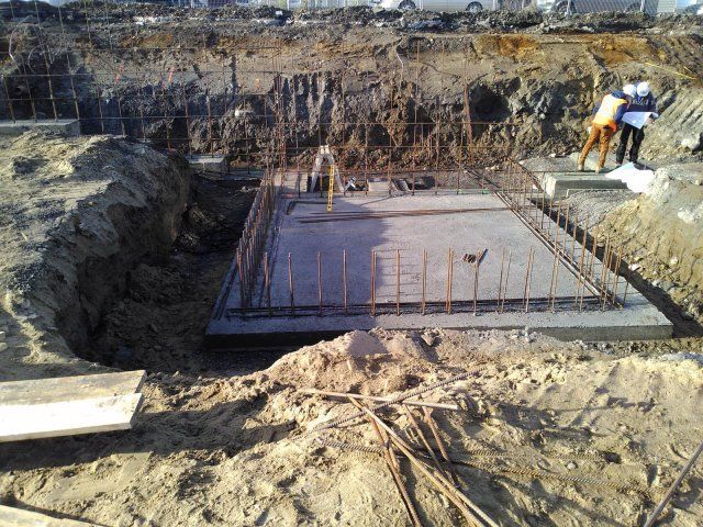 Un chantier de construction avec une grande dalle de béton au milieu