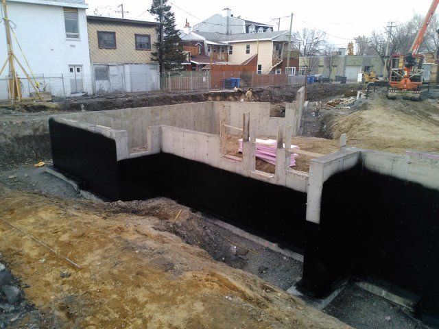 Un grand mur de béton est en cours de construction sur un chantier de construction.