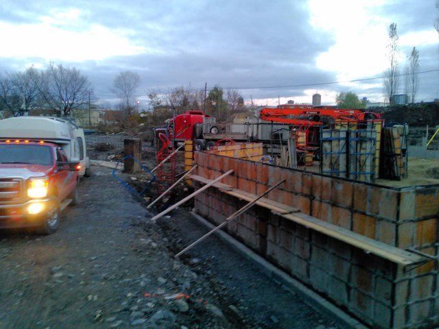 Un camion rouge est garé devant un chantier de construction
