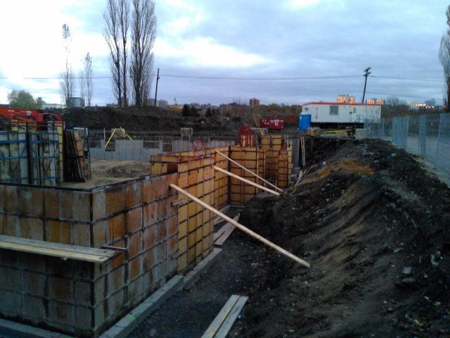 Un chantier de construction avec un gros tas de terre au premier plan