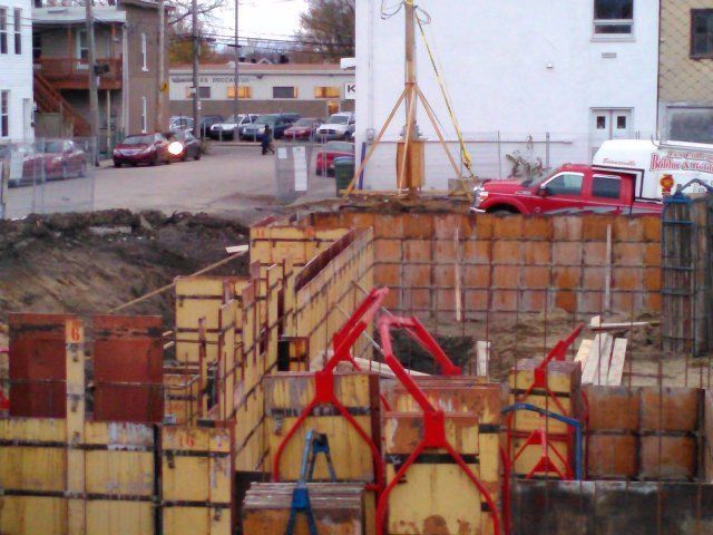 Un camion rouge est garé devant un bâtiment en construction