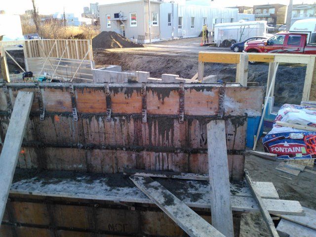 Un camion rouge est garé devant un bâtiment en construction