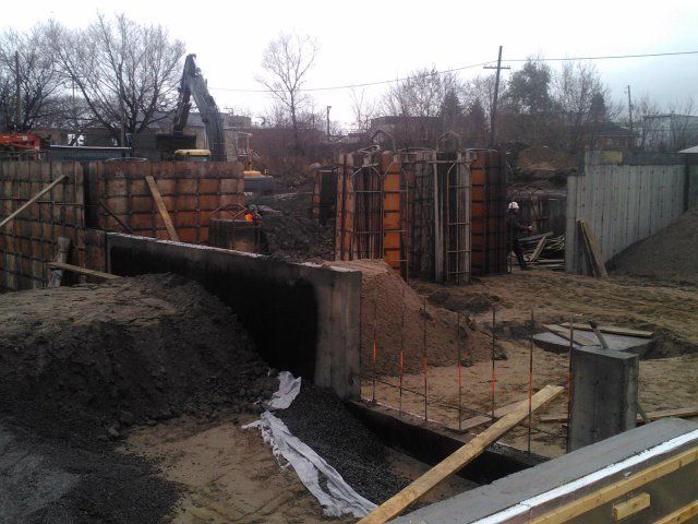 Un chantier de construction avec un gros tas de terre au premier plan