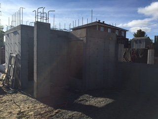 Un grand mur de béton est en construction devant une maison.